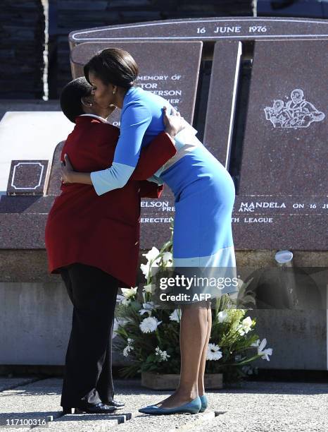 First Lady Michelle Obama and Antoinette Sithole, the sister of Hector Pieterson, a 12-year-old boy killed during the student uprising in protest at...