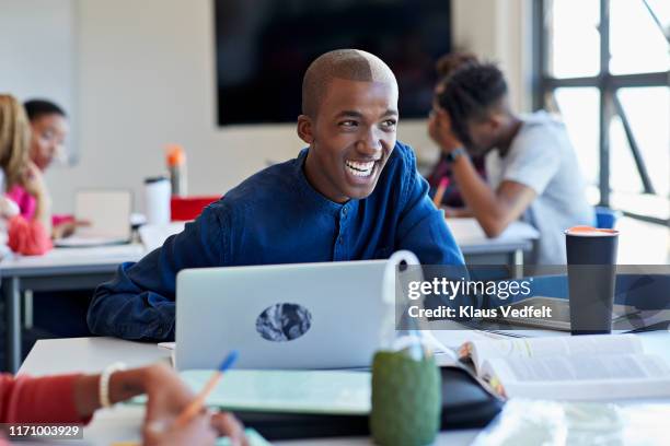 cheerful student looking away with laptop at desk - e learning africa stock pictures, royalty-free photos & images