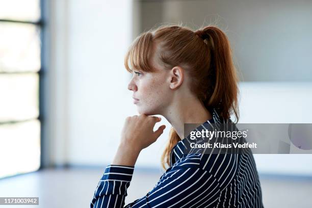 beautiful young woman thinking while looking away - casual woman pensive side view stockfoto's en -beelden