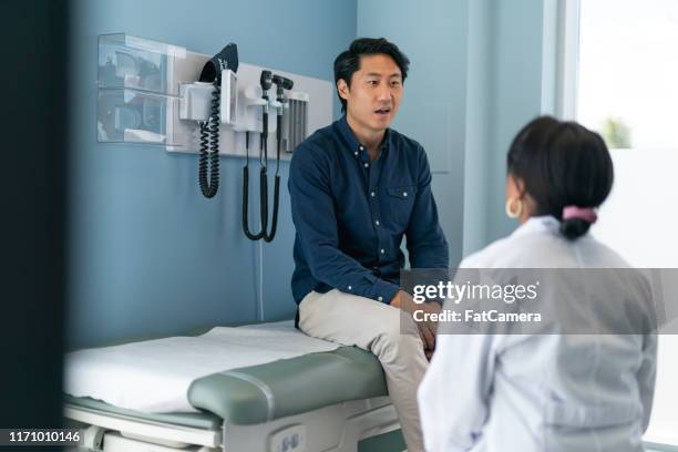 koreanska mannen i samråd med läkare - man talking to doctor bildbanksfoton och bilder
