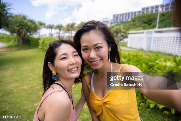 夏のビーチリゾートでセルフ写真を撮る若い女性の友人 - 自分撮り ストックフォトと画像