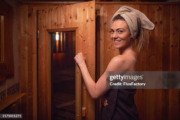 bella donna in asciugamani in piedi di fronte alla sauna - entrare foto e immagini stock