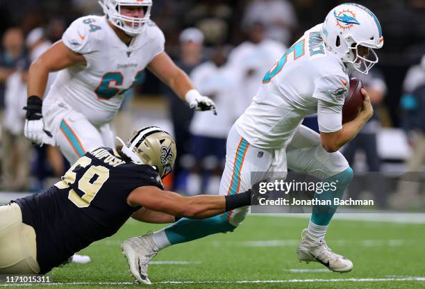 Corbin Kaufusi of the New Orleans Saints tackles Jake Rudock of the Miami Dolphins during the first half of an NFL preseason game at the Mercedes...