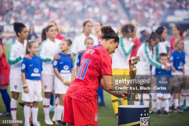 Carli Lloyd of United States of the U.S. Women's 2019 FIFA World Cup Championship team places the FIFA World Cup trophy on the pedestal during the...
