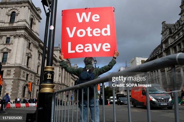 Pro brexit protester holds a placard while protesting outside Parliament while UK MPs get back to work.