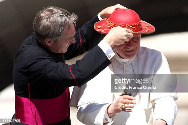 Pope's personal secretary Georg Ganswein adjusts Pope Benedict XVI's 'Saturno' as they arrive at St. Peter's square for the weekly audience on June...