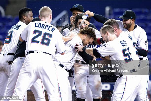 Harold Ramirez of the Miami Marlins celebrates with teammates after hitting a walk-off home run in the twelfth inning against the Cincinnati Reds at...