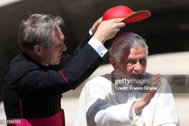 Pope's personal secretary Georg Ganswein adjusts Pope Benedict XVI's 'Saturno' as they arrive at St. Peter's square for the weekly audience on June...