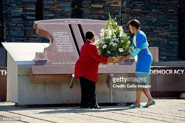 First Lady Michelle Obama and Hector Pieterson's sister Antoinette Sithole place a bouquet of flowers at the Hector Pieterson memorial site on June...