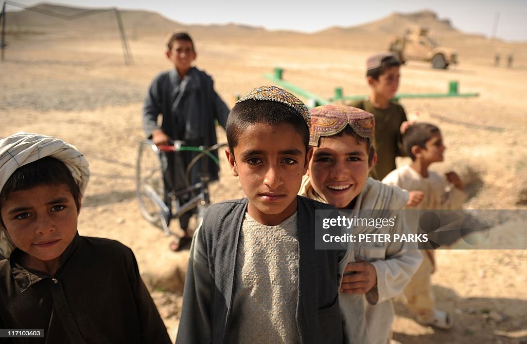 Afghan boys play near the town of Musa Q