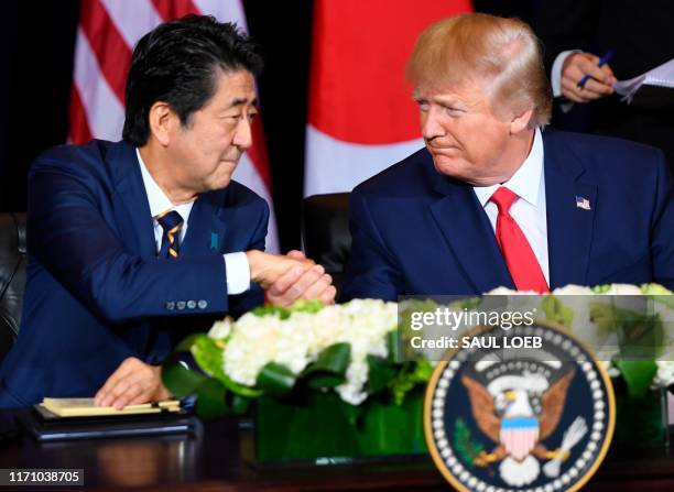 President Donald Trump and Japanese Prime Minister Shinzo Abe shake hands during a meeting on trade in New York, September 25 on the sidelines of the...