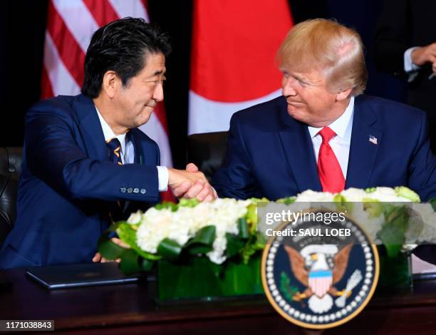 President Donald Trump and Japanese Prime Minister Shinzo Abe shake hands after signing a trade agreement in New York, September 25 on the sidelines...