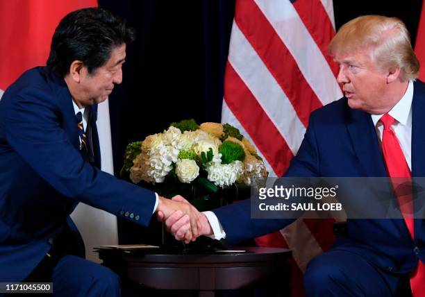 President Donald Trump and Japanese Prime Minister Shinzo Abe shake hands during a meeting in New York, September 25 on the sidelines of the United...