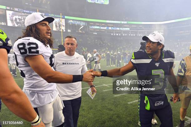 Luke Willson of the Oakland Raiders and Russell Wilson of the Seattle Seahawks catch up after the preseason game at CenturyLink Field on August 29,...