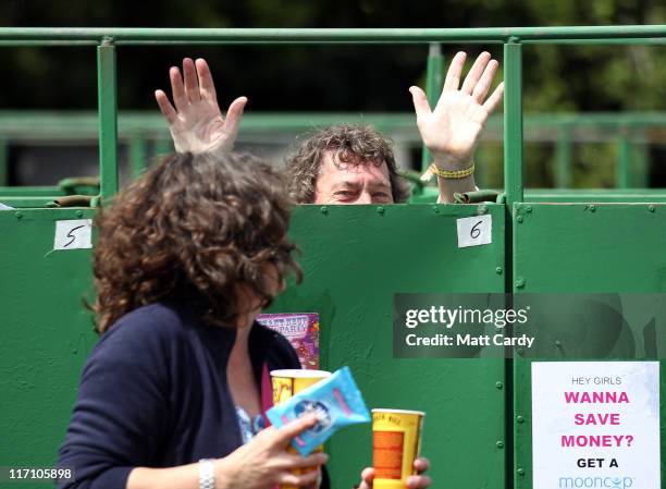 Person waves from the long drop toilets at the Glastonbury Festival site at Worthy Farm, Pilton on June 22, 2011 in Glastonbury, England. Heavy rain...