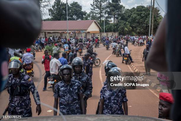 Police officers stare down "people power" opposition supporters in Hoima Wine aka Robert Kyagulanyi, campaigned in Hoima ahead of a by-election. It...