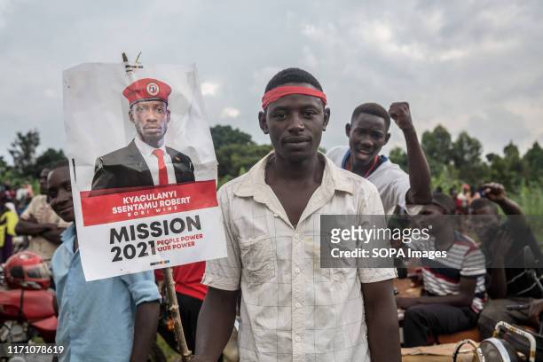 Bobi Wine and "people power" opposition supporter, holds a placard during a rally in Hoima. Wine aka Robert Kyagulanyi, campaigned in Hoima ahead of...