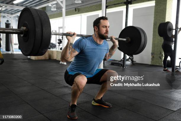 mid adult man weight lifting in gym - barra de peso - fotografias e filmes do acervo