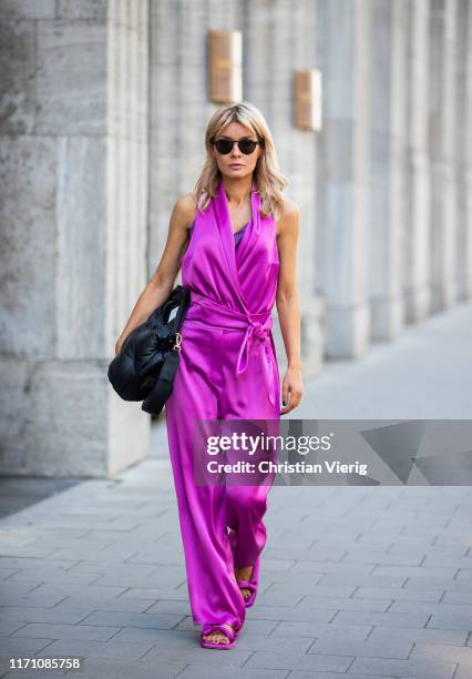 Gitta Banko is seen wearing a rosebud colored satin wide leg pants with rounded waistband, a rosebud wrap satin top and puffed shape flat Yolo...