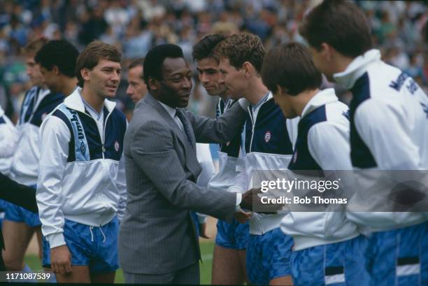 Brazilian soccer player Pele greets English soccer player Clive Allen before the centenary match of the British Football League against the Rest of...