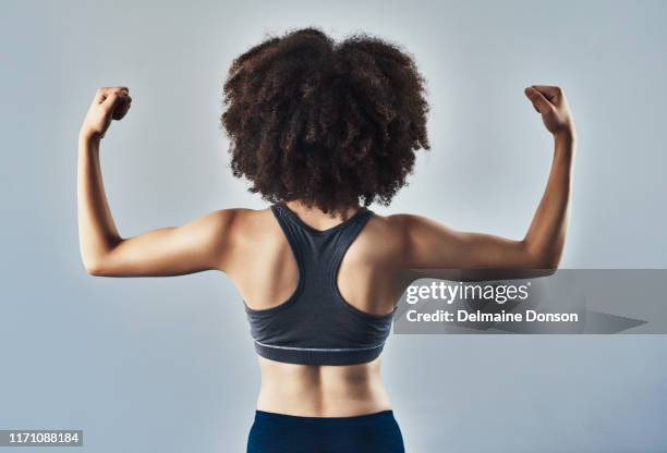 Woman flexing her muscles and showing her toned back Royalty-Free