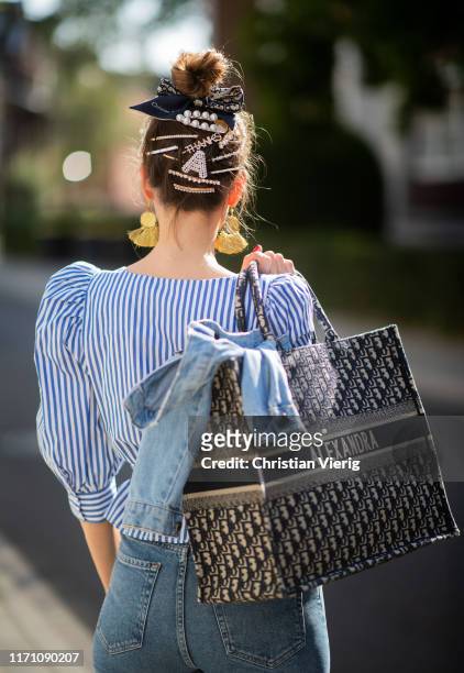 Alexandra Lapp is seen wearing a blue Dior Book Tote Dior Oblique, Goldsign blue jeans, a blue and white striped wrap blouse from Zara, blue...