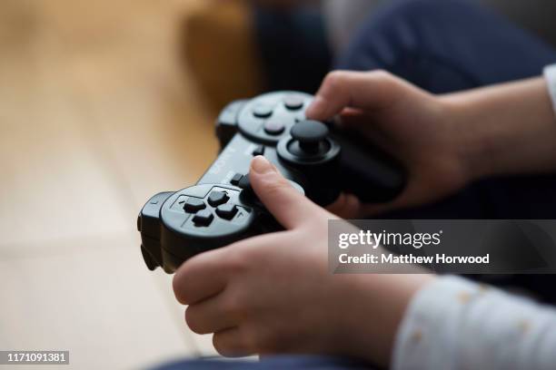 Close-up of a child's hands holding a Playstation controlling on February 21, 2017 in Cardiff, United Kingdom.