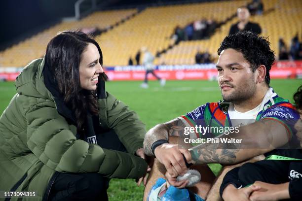 Prime Minister Jacinda Ardern stops to talke with Issac Luke of the Warriors who sits with his son Adaquix following the round 24 NRL match between...