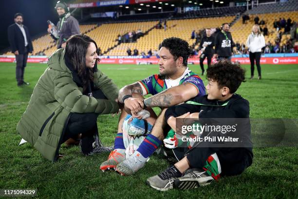 Prime Minister Jacinda Ardern stops to talke with Issac Luke of the Warriors who sits with his son Adaquix following the round 24 NRL match between...