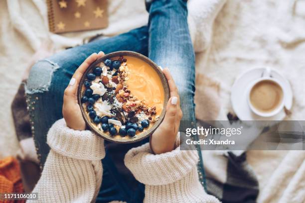 vrouw houdt een pompoen smoothie bowl - almond meal stockfoto's en -beelden