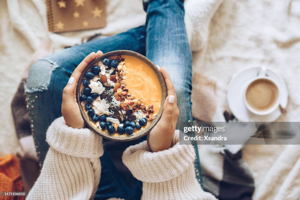 Woman holding a pumpkin smoothie bowl