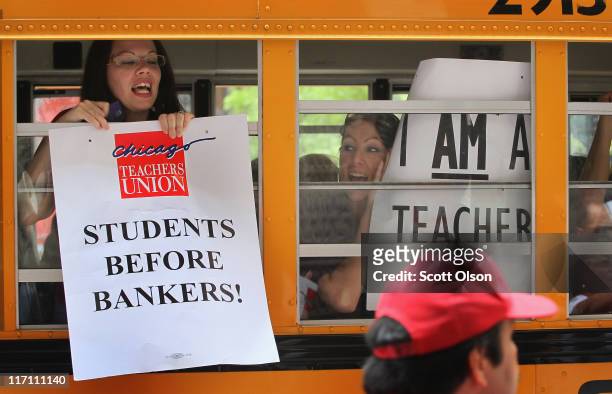 Chicago school teachers display protest signs from inside a school bus as they leave a demonstration outside the Chicago Board of Education building...