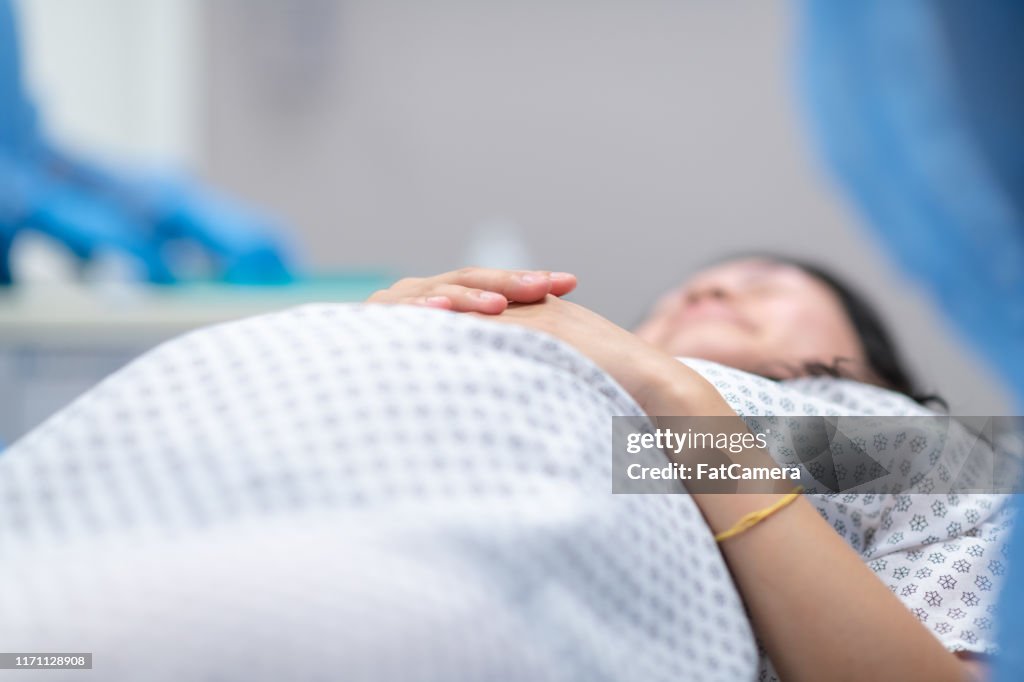 妊娠中の女性は帝王切開を受け取る前に手術台に横たわる