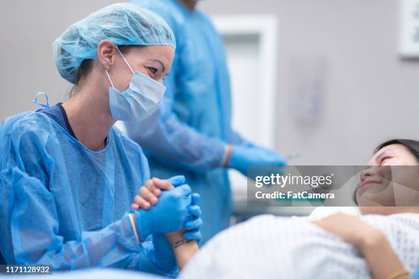 médico que sostiene la mano del paciente antes de la cirugía - comadrona fotografías e imágenes de stock