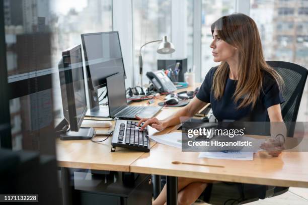 confident latin american businesswoman working very focused at her office - office concentration stock pictures, royalty-free photos & images