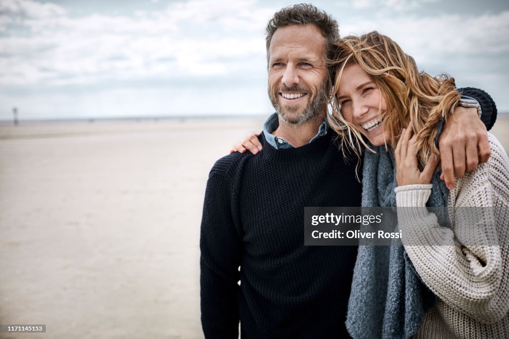 Happy couple hugging on the beach