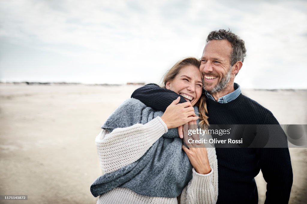 Happy couple hugging on the beach