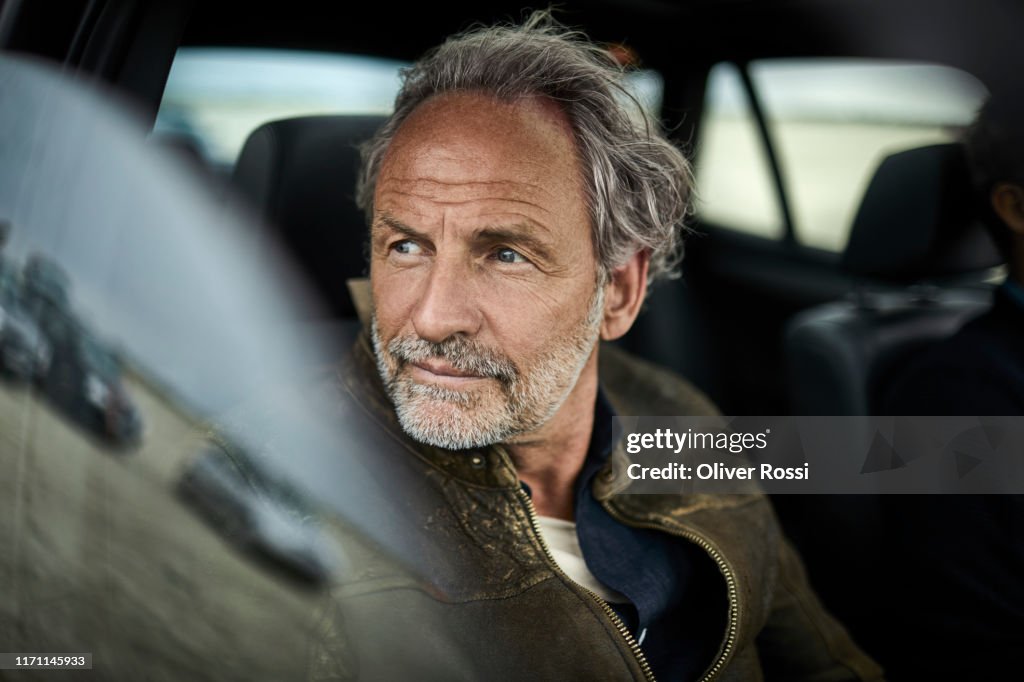 Portait of man with grey hair in a car