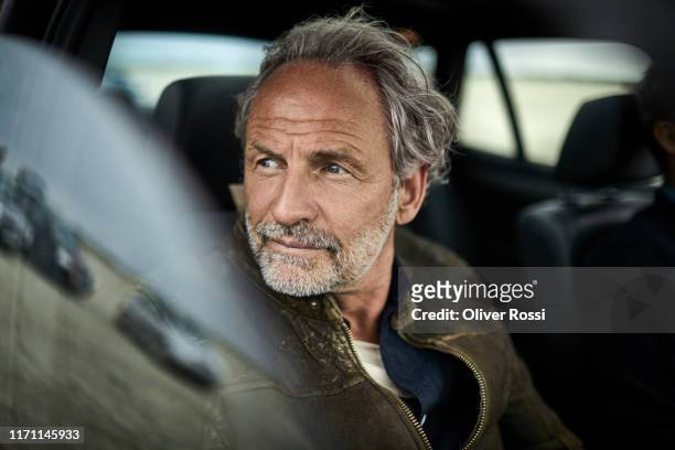 portait of man with grey hair in a car - driving photos et images de collection