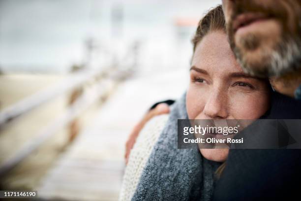 affectionate couple hugging on the beach - contemplation couple stock pictures, royalty-free photos & images