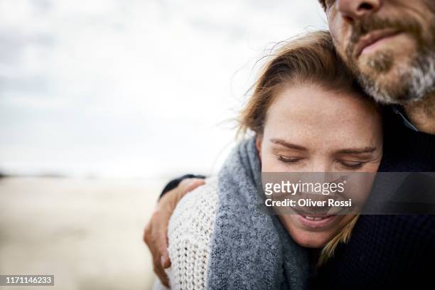 affectionate couple hugging on the beach - love emotion stock pictures, royalty-free photos & images