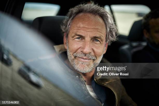 portait of confident man with grey hair in a car - männer über 40 stock-fotos und bilder