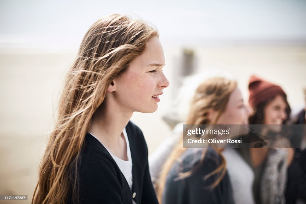 Portrait of girl on the beach with women in background