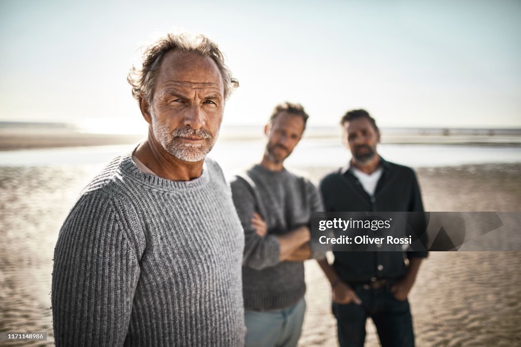Portrait of three confident men on the beach