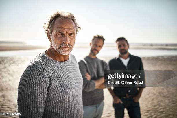 portrait of three confident men on the beach - 3 men standing outside stockfoto's en -beelden