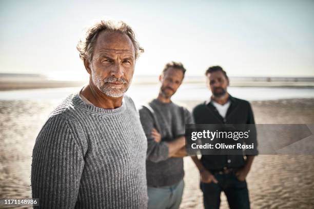 portrait of three confident men on the beach - 3 men standing outdoors stock pictures, royalty-free photos & images