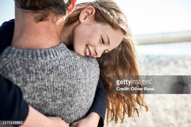 happy daughter hugging father on the beach - fonds marins foto e immagini stock