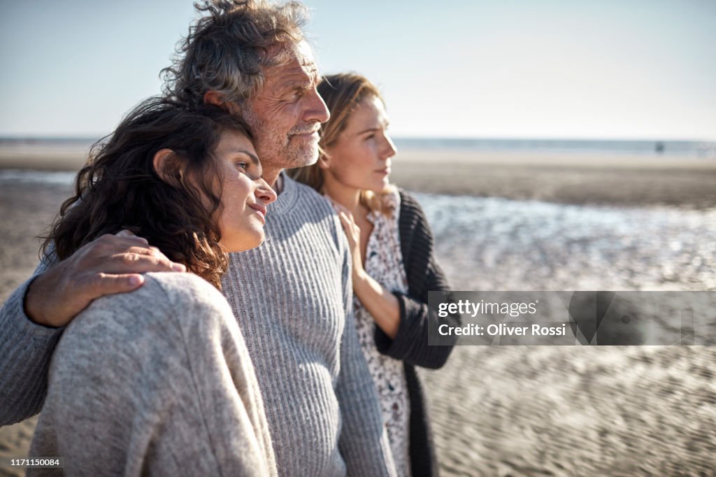 Two women and mature man on the beach