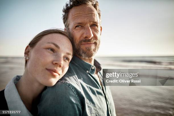 portrait of man and young woman by the sea - father and grown up daughter stockfoto's en -beelden