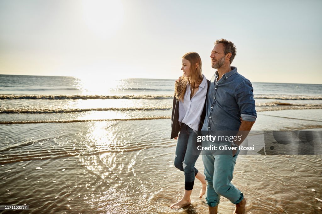 Man and young woman wading in the sea